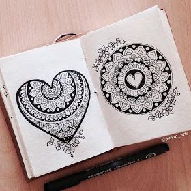 two notebooks with black and white designs on them, one has a heart in the middle