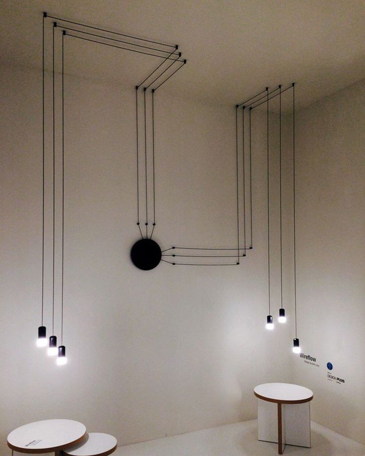 three round tables with lights hanging from the ceiling