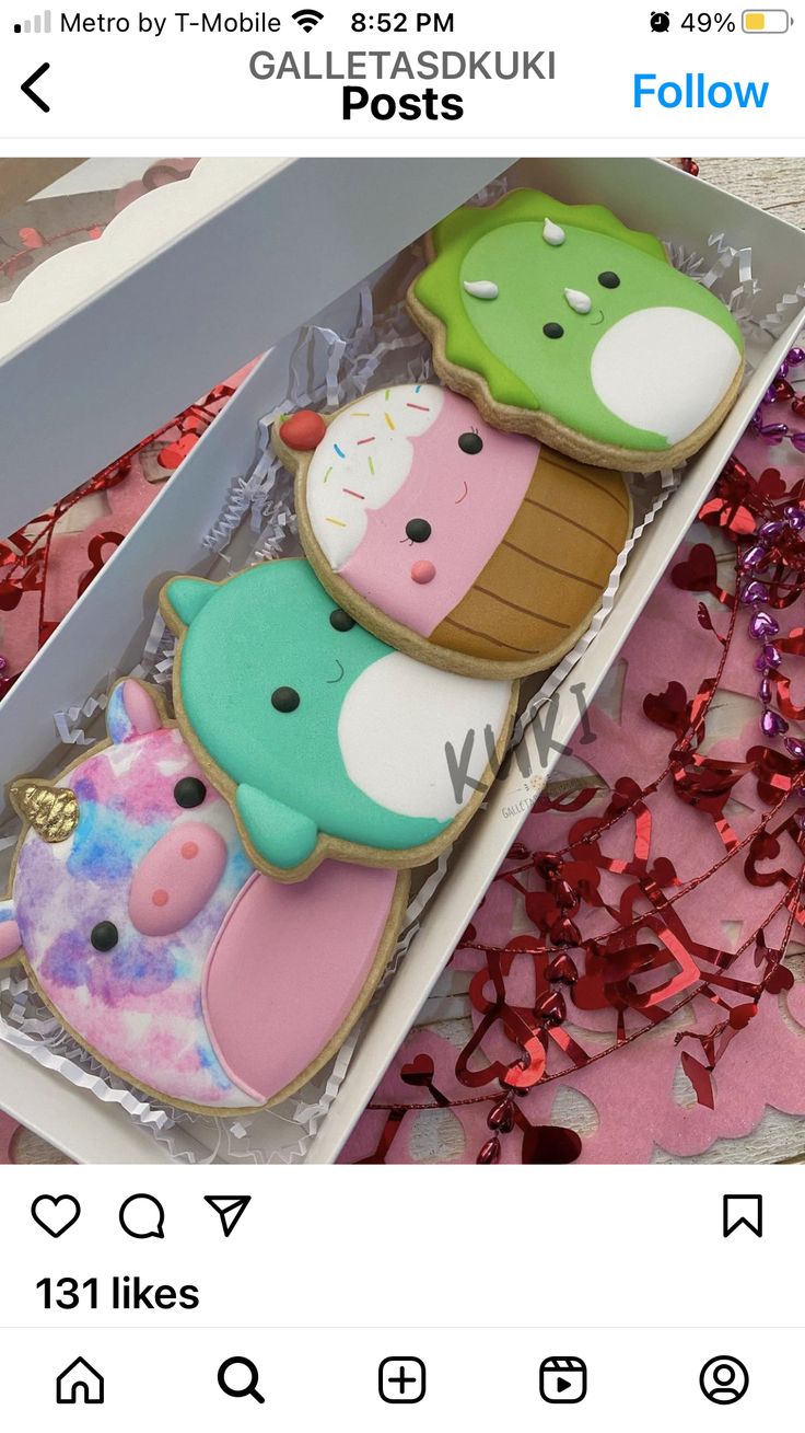 three decorated cookies in a box with confetti