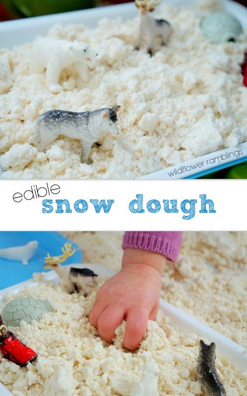 a child's hand is in the middle of a bowl of snow dough with toy animals on top