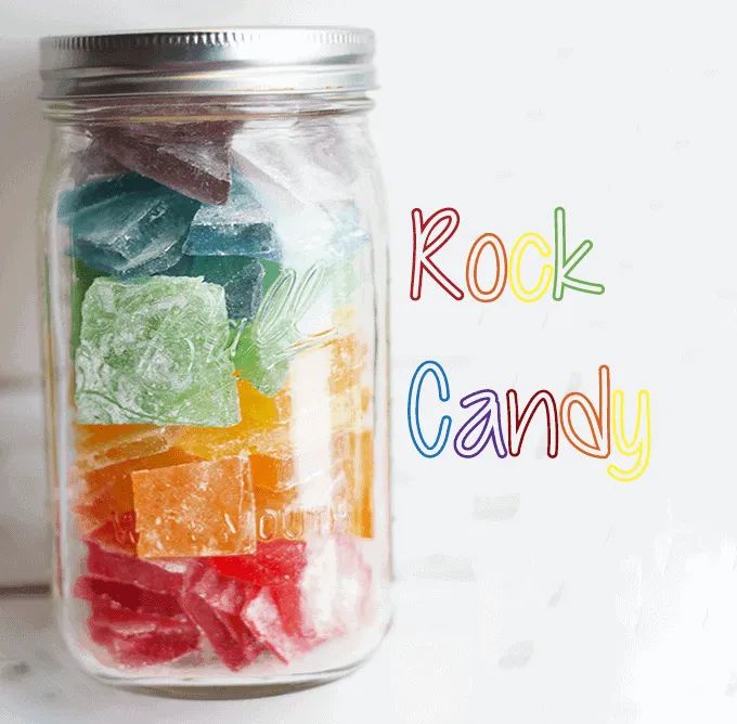 a jar filled with gummy bears sitting on top of a white counter next to the words rock candy