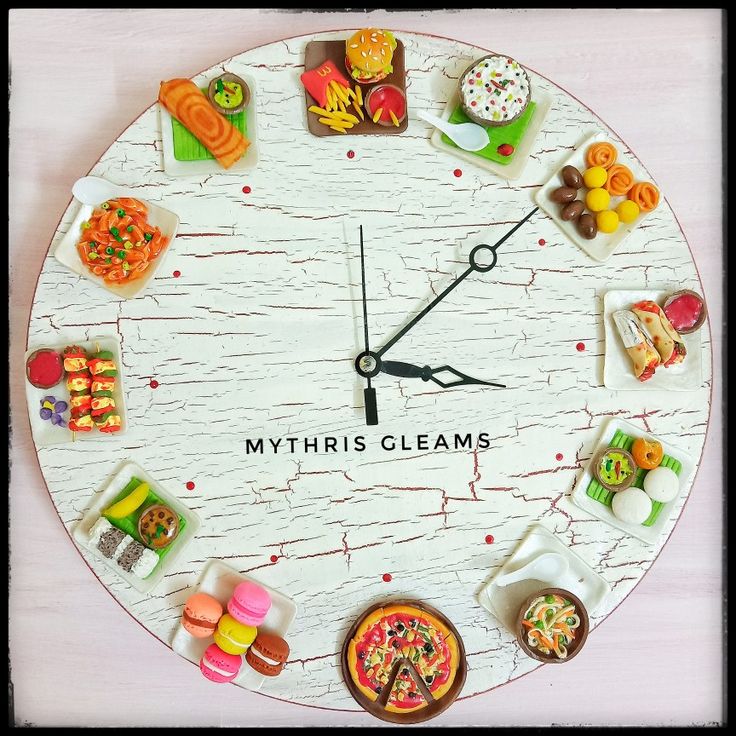 a white clock with lots of different foods on it's face and the words, myrths glams