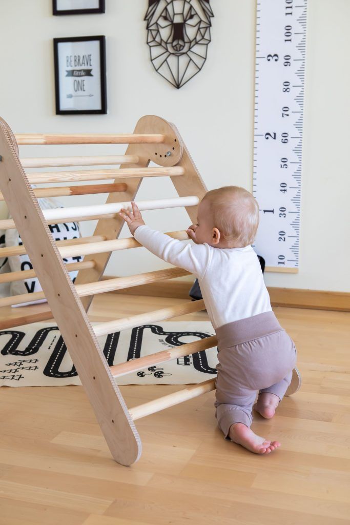 a baby climbing up the stairs to reach it's own height with his hands