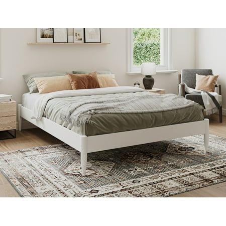 a white bed sitting on top of a wooden floor