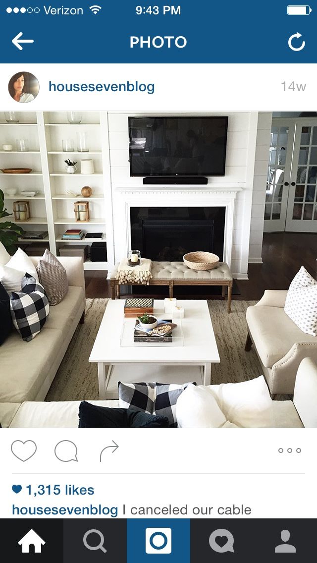 a living room filled with furniture and a flat screen tv mounted on a wall above a fire place