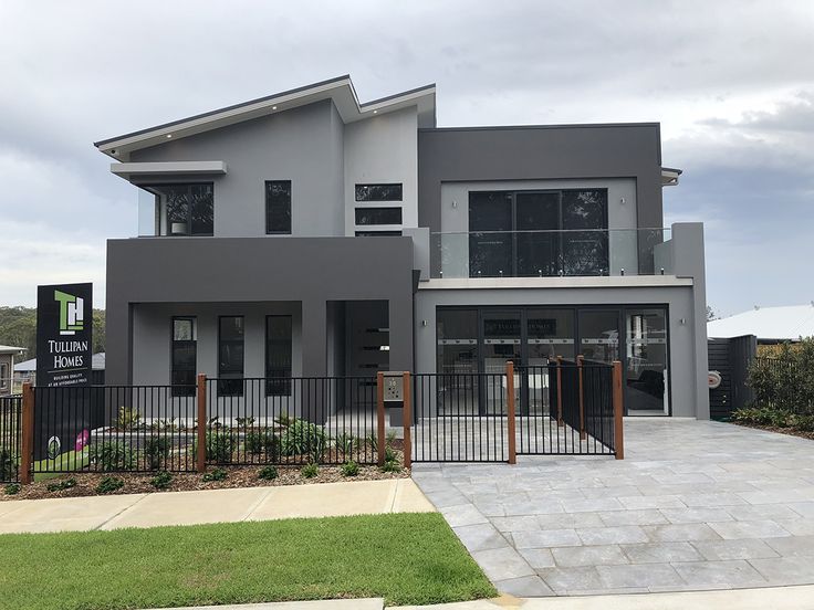 a grey house with a black fence and gate