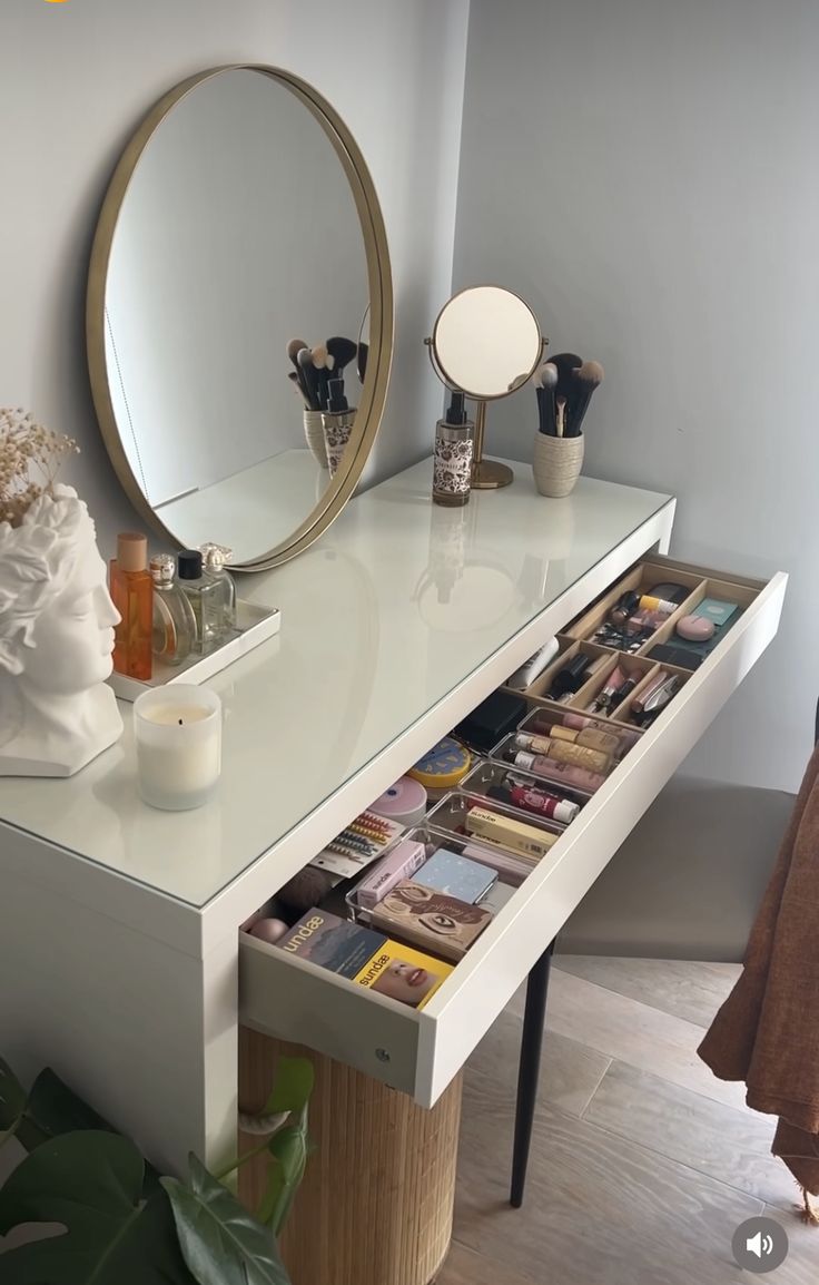 a vanity with magazines on it and a round mirror