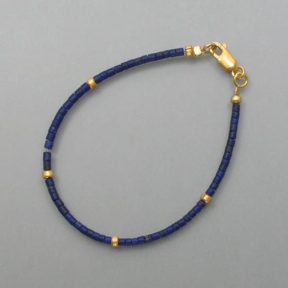 This lapis lazuli bracelet has a classic design throughout. Small rolls of lapis lazuli line up and are interrupted at regular intervals by similarly shaped gold-plated silver parts. The intense and dull blue of the lapis lazuli and the warm color of the gold combine to form a wonderfully uncomplicated and stylish bracelet. Here you will find the matching necklace or matching earrings Dimensions: Diameter of the rollers: 2 mm, length: 19 cm Gold Beaded Lapis Lazuli Bracelets, Gold Bracelets With Lapis Lazuli And Natural Stones, Hand-strung Gold Lapis Lazuli Bracelets, Gold Lapis Lazuli Beaded Bracelets With Round Beads, Dull Blue, Lapis Lazuli Bracelet, Stylish Bracelet, Matching Necklaces, Ear Jewelry