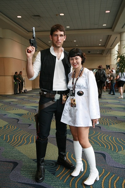 a man and woman dressed up as star wars characters posing for a photo in an airport