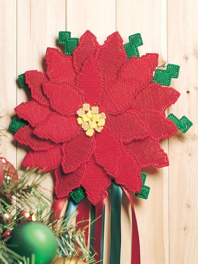 a red poinsettia with green leaves on top of it next to christmas decorations