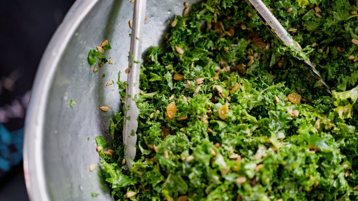 a metal bowl filled with lots of green food