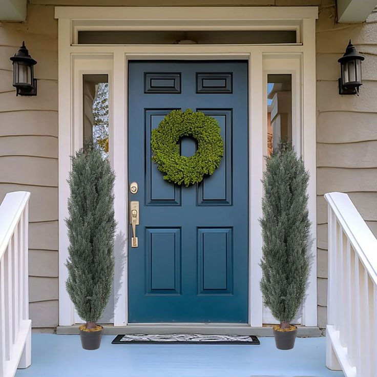 a blue front door with two potted plants next to it