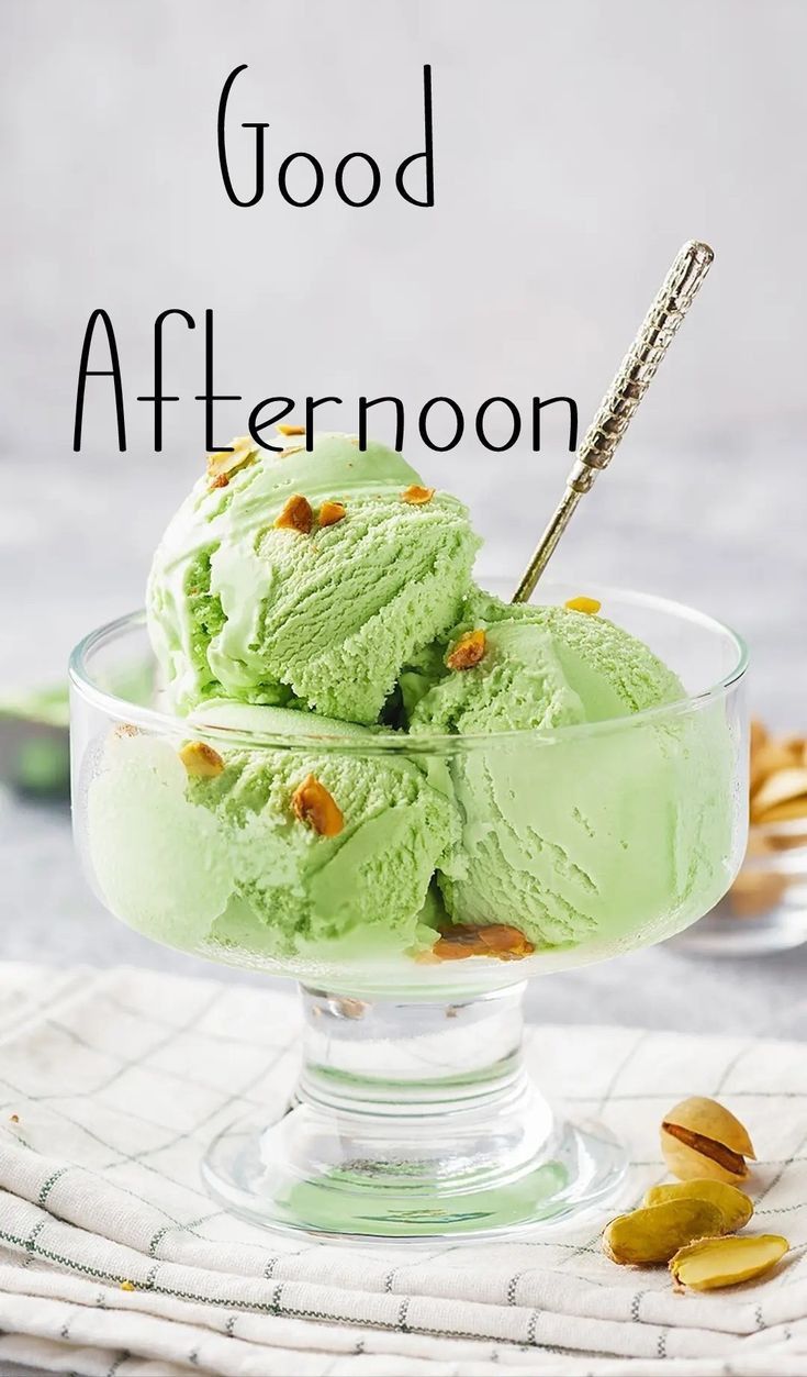 two scoops of green ice cream in a glass bowl with the words good afternoon on it