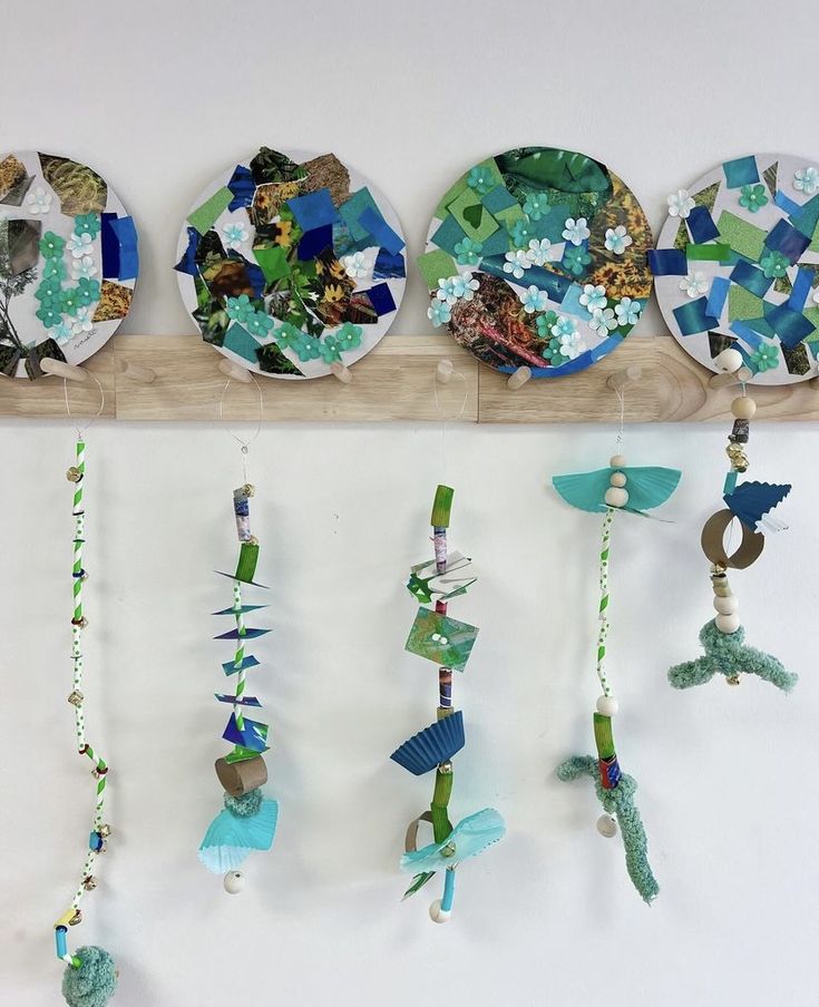 three plates are hanging on a wall with fish and seaweed decorations attached to them