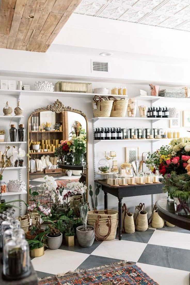 a room filled with lots of vases and flowers on shelves next to each other