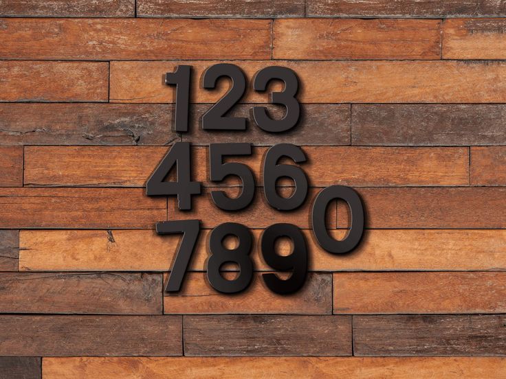 the numbers are arranged in black on a wooden wall