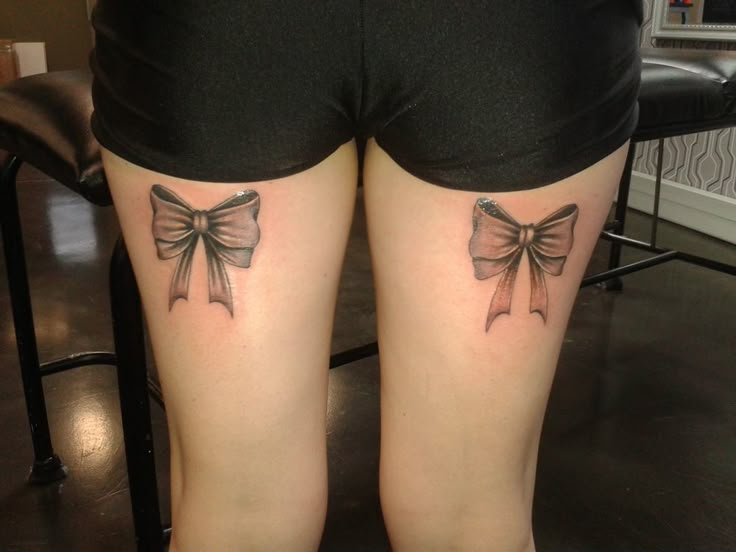 two bow tattoos on the legs of a woman's thighs, both with bows