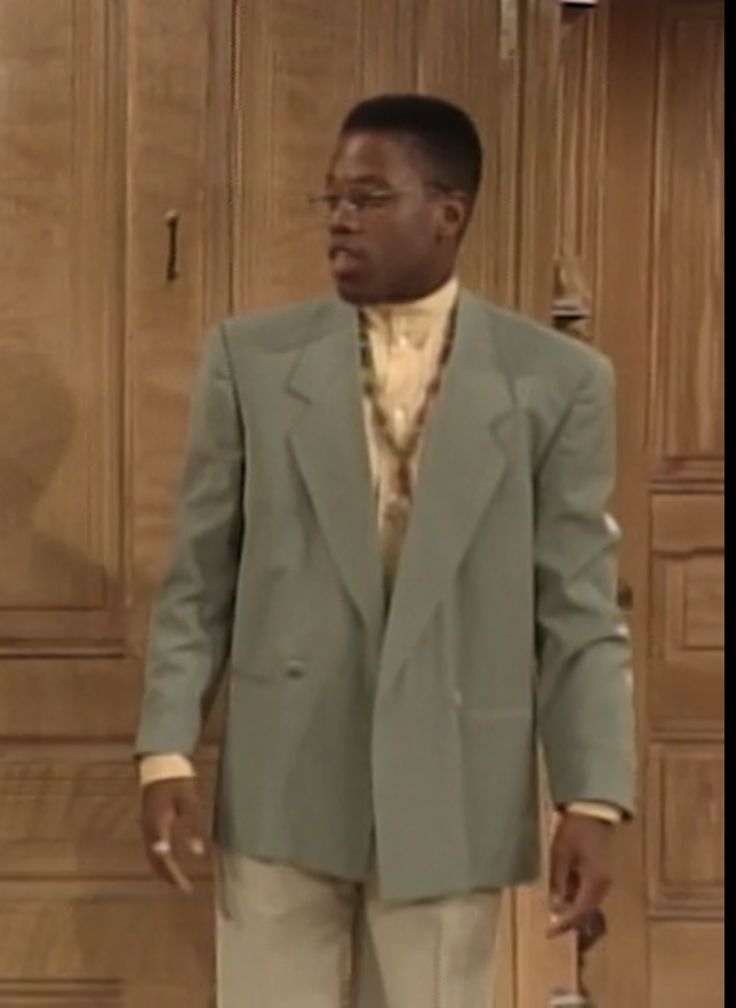 a man in a suit and tie standing next to a door