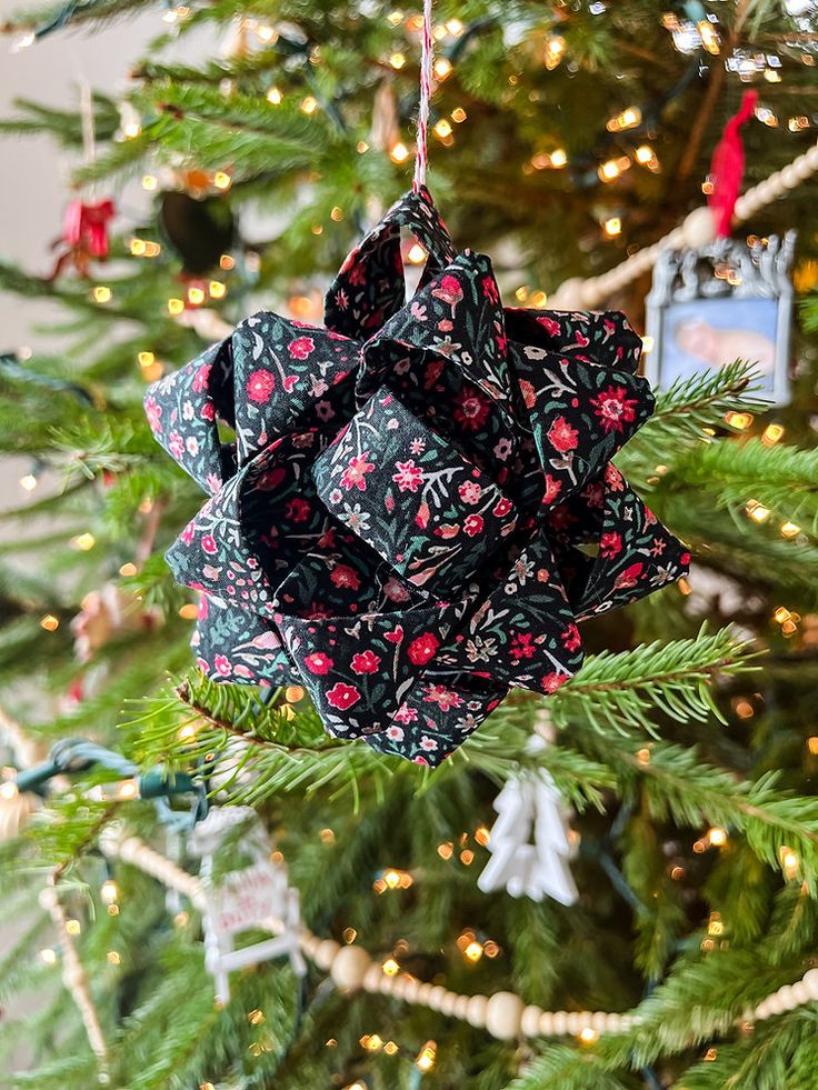 an ornament hanging from the christmas tree is decorated with black and red fabric