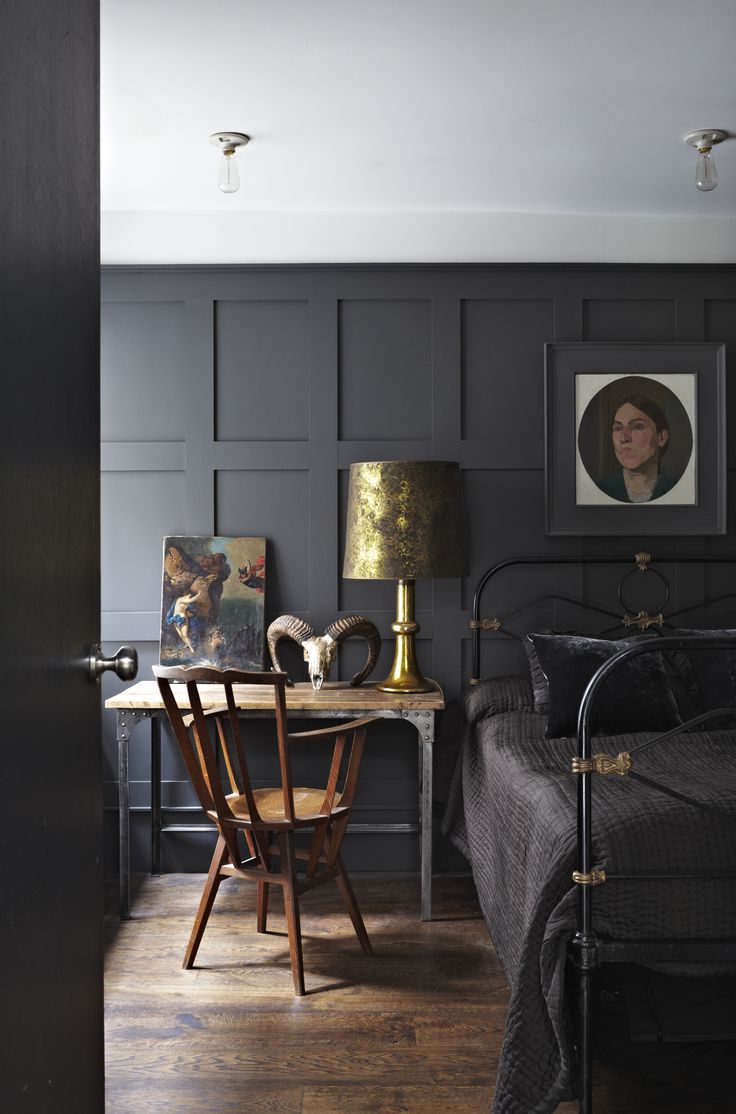 a bed room with a neatly made bed next to a night stand and a table