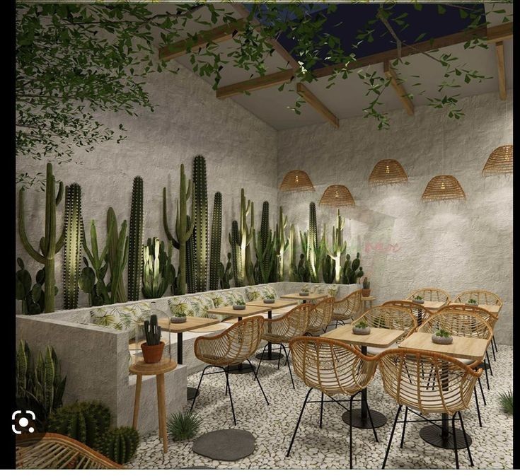 an outdoor dining area with tables, chairs and cactus plants on the wall behind it