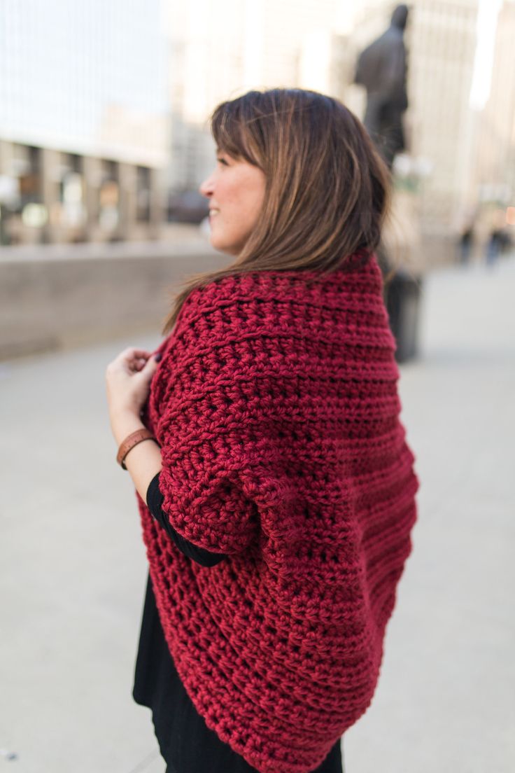 a woman wearing a red crocheted shawl