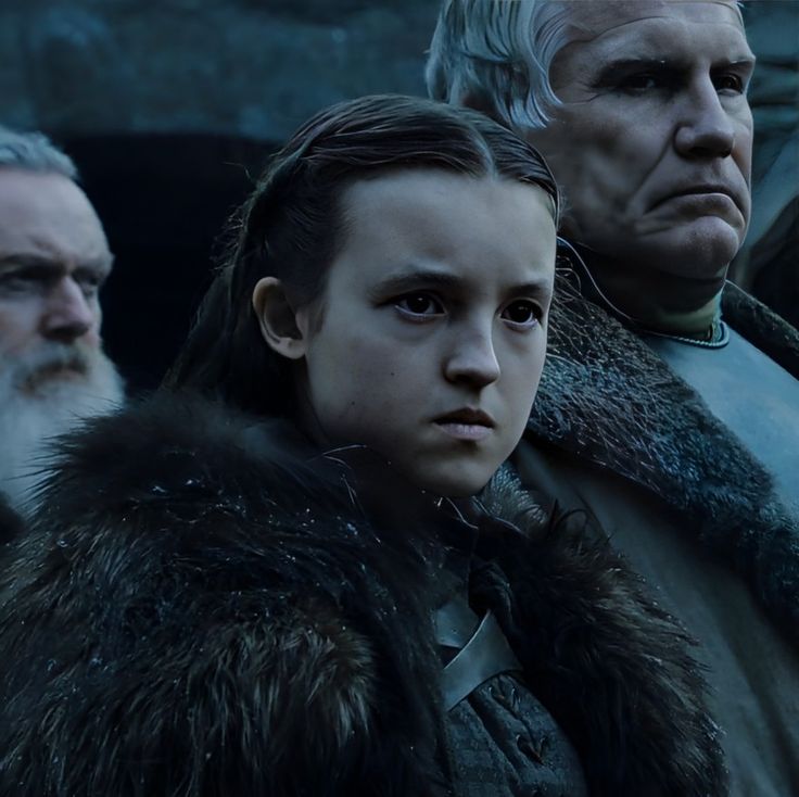 game of thrones characters standing in front of an older man with white hair and beard