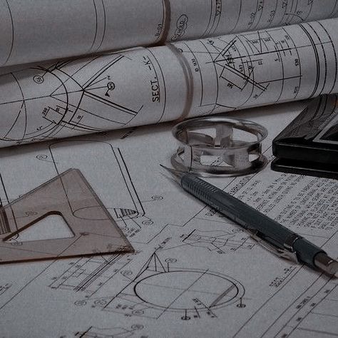 some construction drawings are laying on top of each other with a pair of eyeglasses next to them