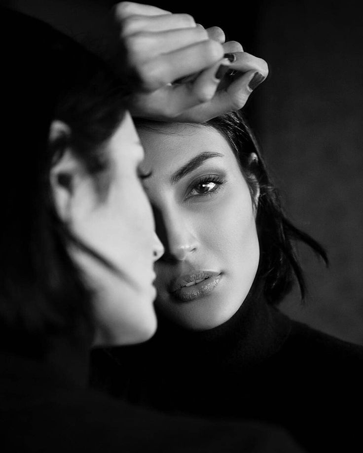 black and white photograph of two women touching each other's foreheads with their hands