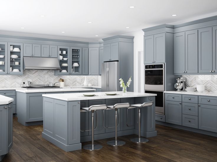 a large kitchen with gray cabinets and white counter tops