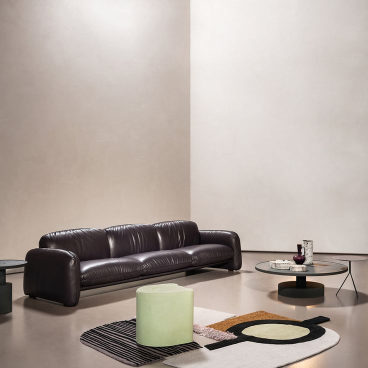 a black leather couch sitting on top of a hard wood floor next to a table