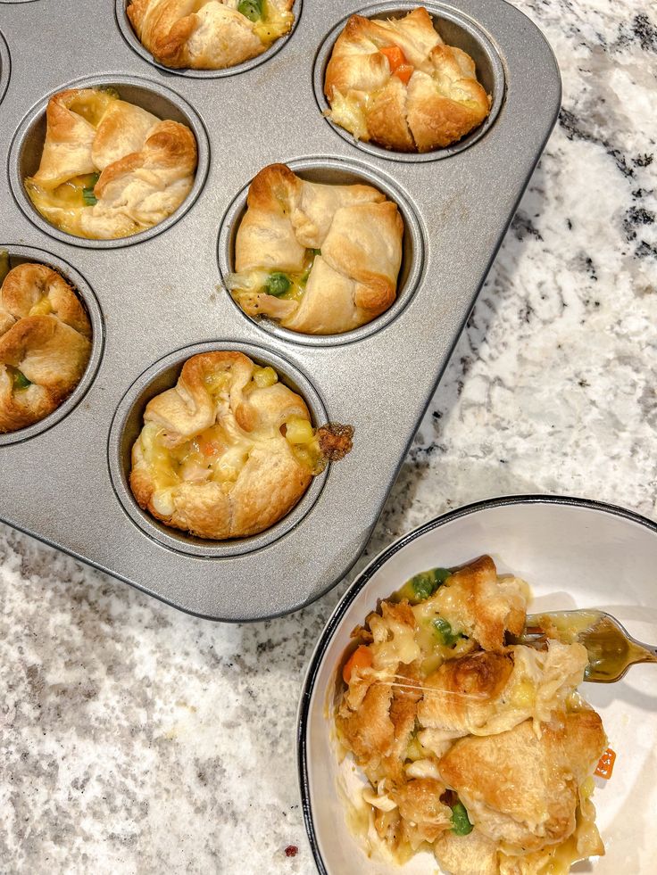 a muffin tin filled with lots of food next to a white plate full of cupcakes