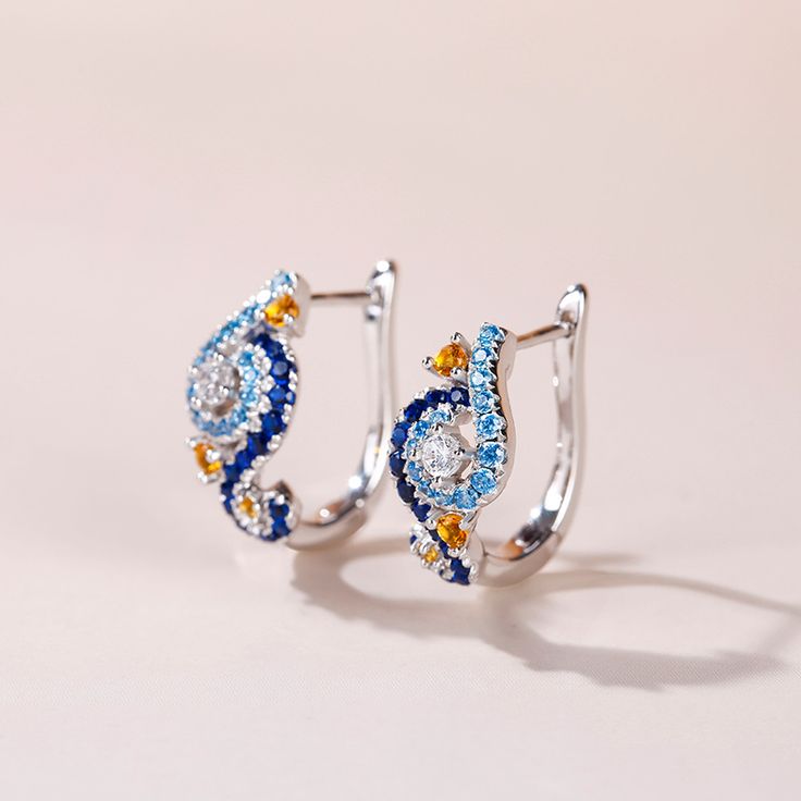 In a stunning display of style and craftsmanship, these earrings are brought to you. A combination of light blue, midnight blue, yellow gold and white stones, the earrings are a premium miniature version of Van Gogh's timeless Starry Night painting. This piece of work reminds us to trust our dreams and not believe the critics of the world. "There is always hope, even in the darkest of times." So trust your dream and let this alluring jewelry make a statement.Carat Weight: 2.584 ctStone Size: 2.5 Blue Diamond Drop Earrings For Anniversary, Luxury Blue Diamond Drop Earrings, Blue Gemstone Diamond Earrings For Anniversary, Blue Teardrop Diamond Earrings, Blue Diamond Gemstone Earrings For Anniversary, Blue Topaz Multi-stone Earrings, Luxury Blue Diamond Earrings With Accents, Gift Blue Sapphire Diamond Earrings, Blue Sapphire Diamond Earrings As Gift