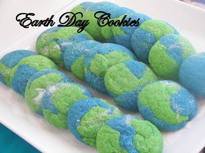 blue and green cookies on a white plate with the words earth day cookies above them