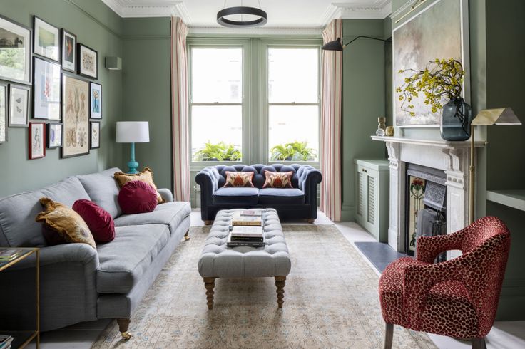 a living room with couches, chairs and a fire place in the middle of it