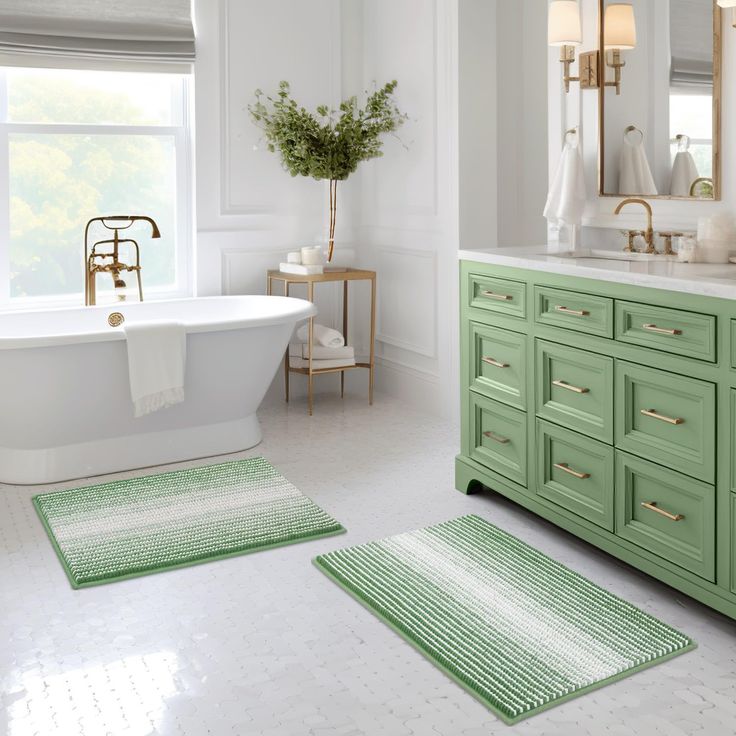 a bathroom with two rugs on the floor and a bathtub in the background