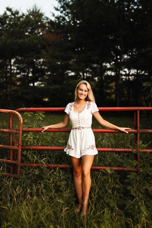 a woman standing in front of a red fence