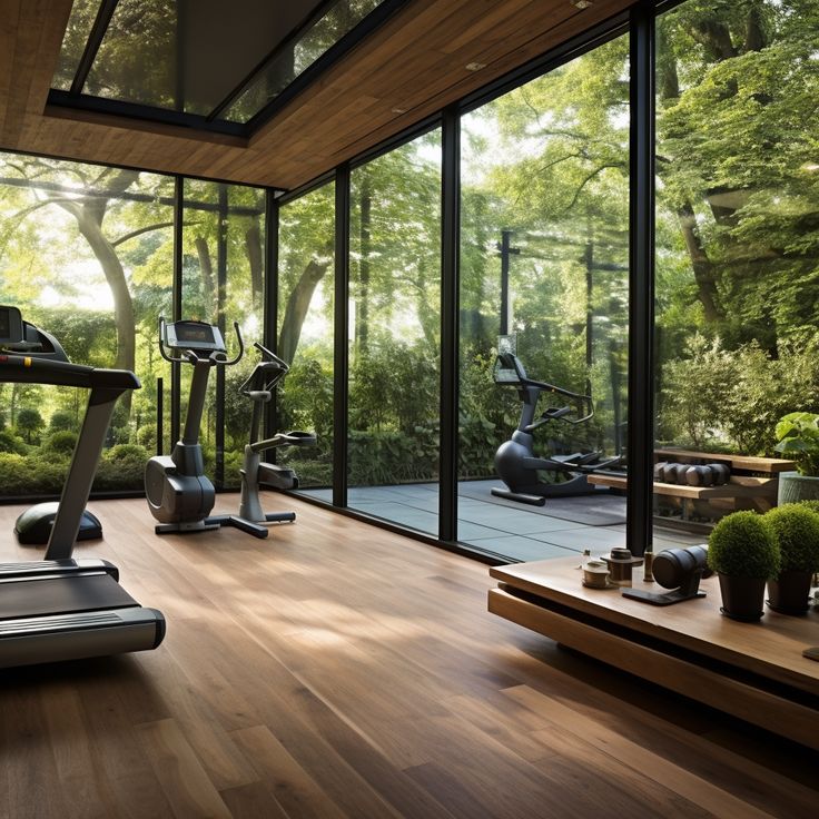 there are many treadmills in the room with glass walls and trees behind them