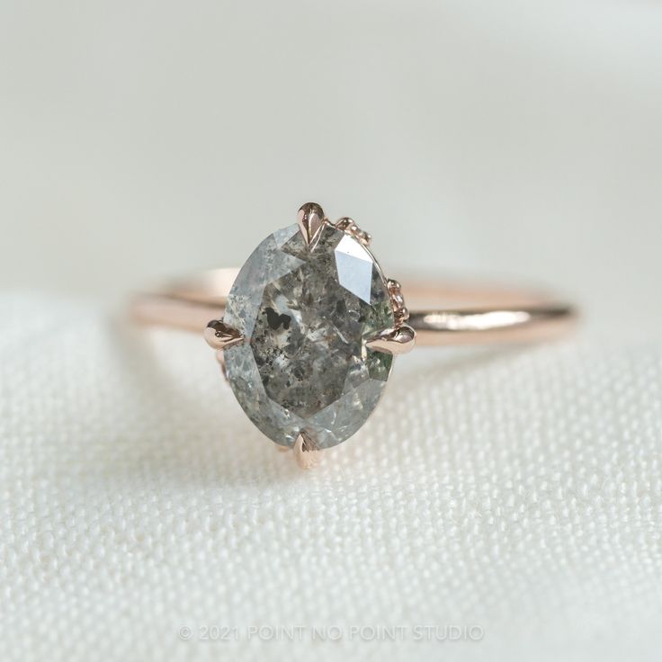 a close up of a diamond ring on a white cloth