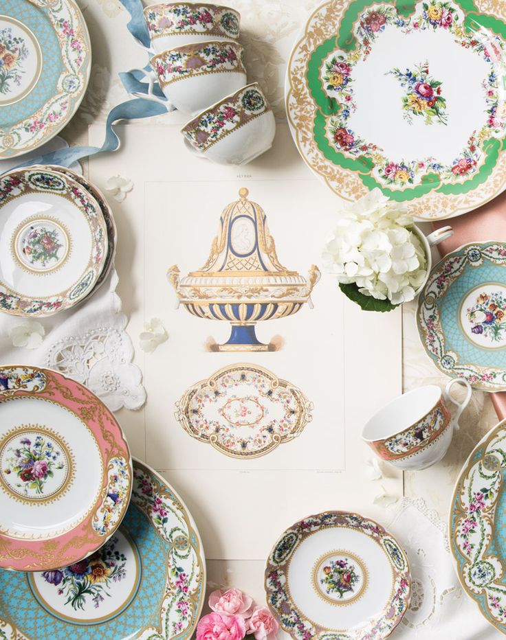 a table topped with lots of plates covered in flowers and saucer dishes on top of each other