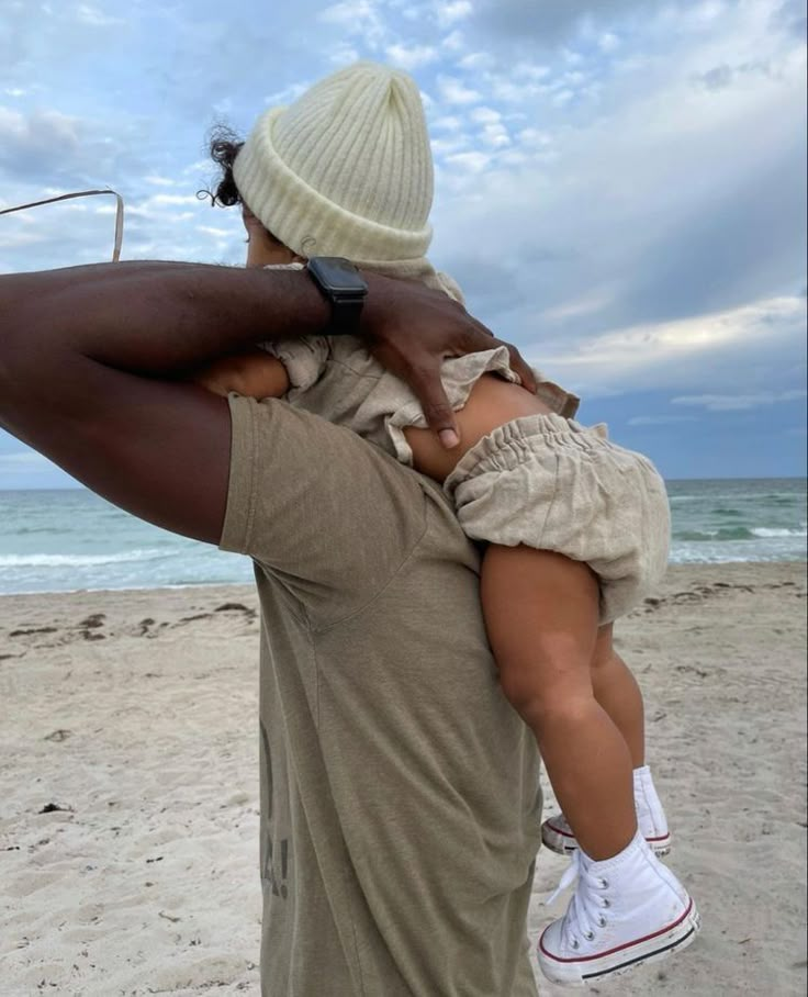 a man holding a child on the beach