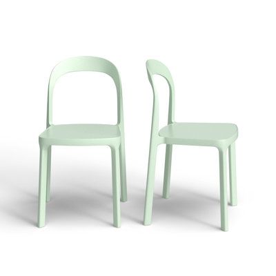 two green chairs sitting next to each other on a white surface with one chair facing the other