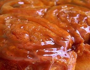 cinnamon buns with caramel glaze sitting on top of each other