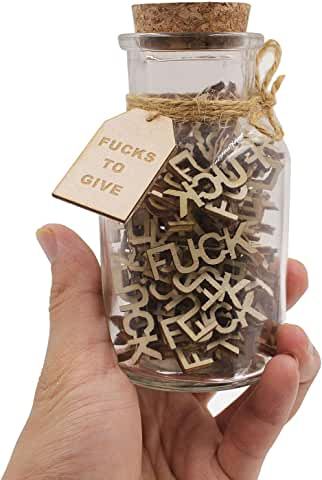 a hand holding a glass jar filled with letters