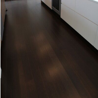 an empty kitchen with wood floors and white cabinets