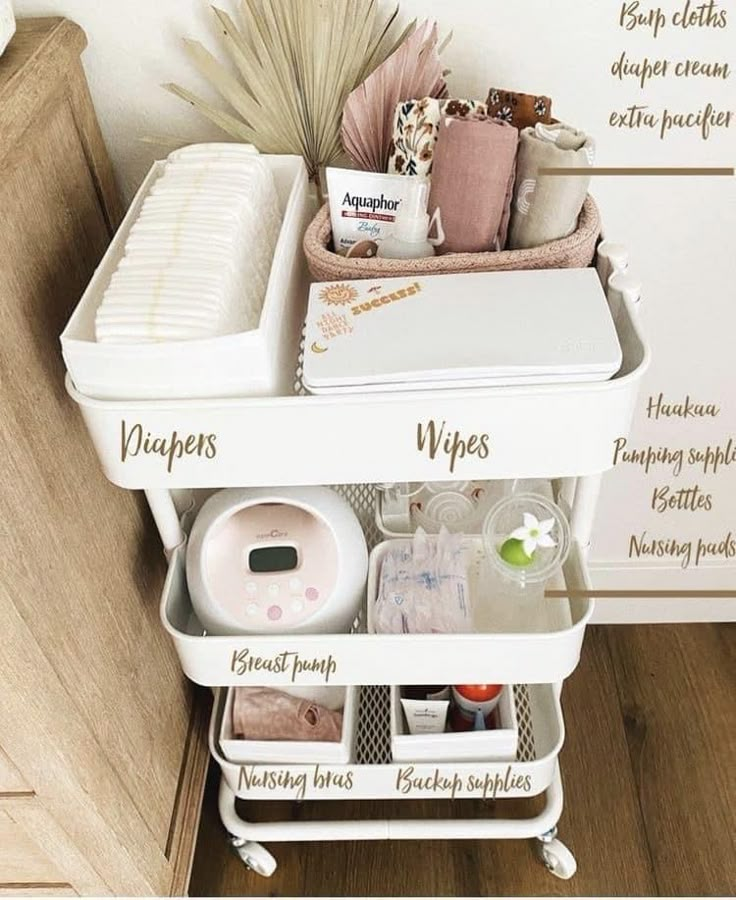 a white cart with lots of items in it on top of a wooden floor next to a wall