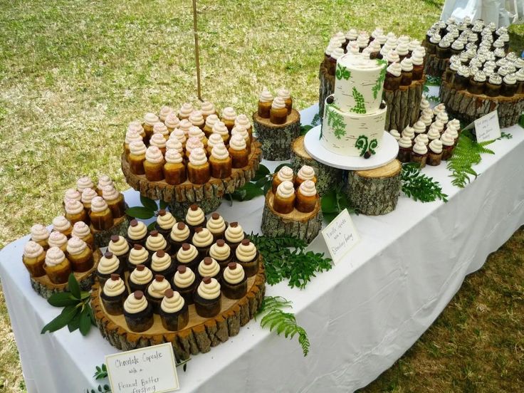 a table topped with lots of cupcakes and cakes