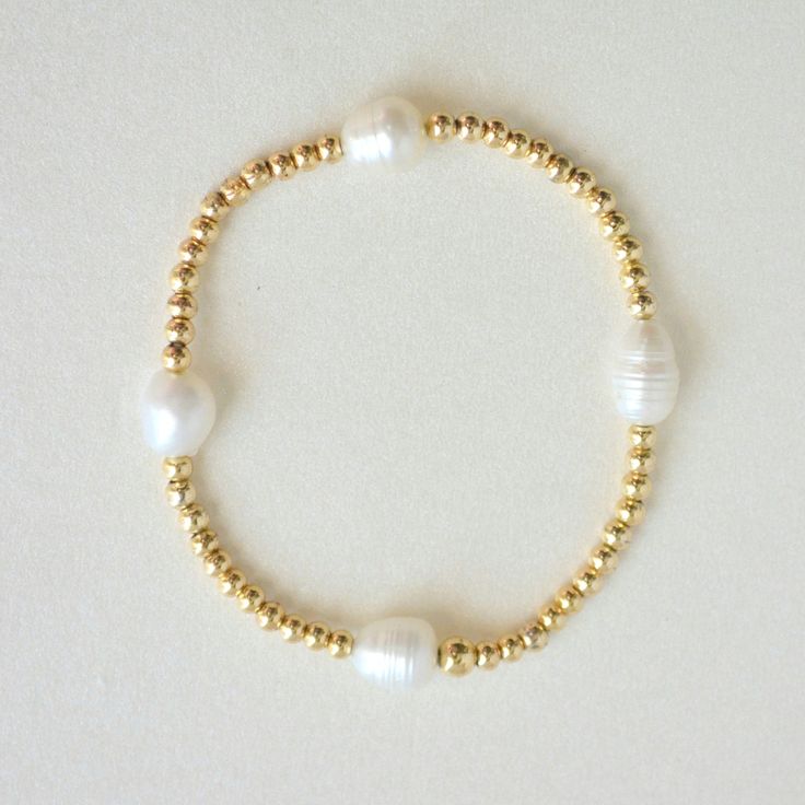 Our gold-filled beaded bracelet and pearls is the epitome of versatile elegance. Perfect for any occasion, these classic and timeless pieces are designed for everyday wear. Adorn yourself with effortless sophistication. The beads are strung on a premium stretch cord.SOLD BY ONE BRACELETDETAILS:- 14K Gold-filled beads, Natural Freshwater Pearls ( due they are natural pearls may vary the size and shape) What is 14k Gold-Fiiled ? Gold-filled jewelry is a type of jewelry that consists of a layer of Gold Bond, Pure Gold, Base Metal, Gold Filled Jewelry, Shape Design, Natural Pearls, Gold Plated Jewelry, How To Make Beads, Pearl Beads