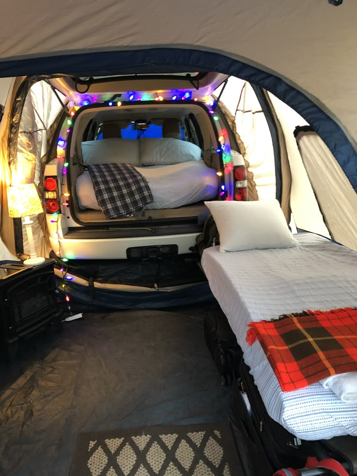 the interior of a camper van with two beds in it and lights all around