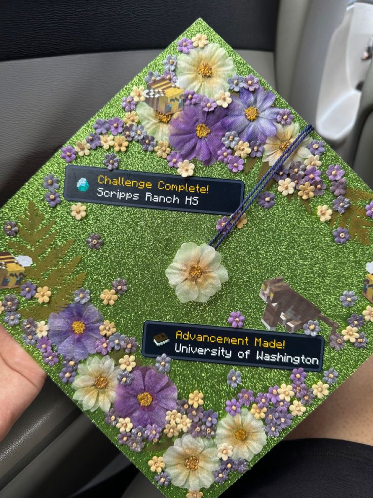 someone is holding up a graduation cap with flowers on it